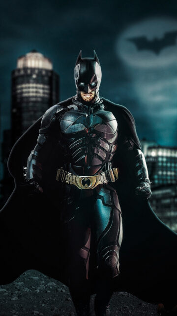 Battle-Damaged Batman Standing in Gotham City Mobile Wallpaper