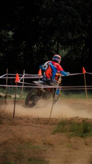 Adrenaline-Fueled Motocross Dirt Bike Rider Racing Through Dust Wallpaper