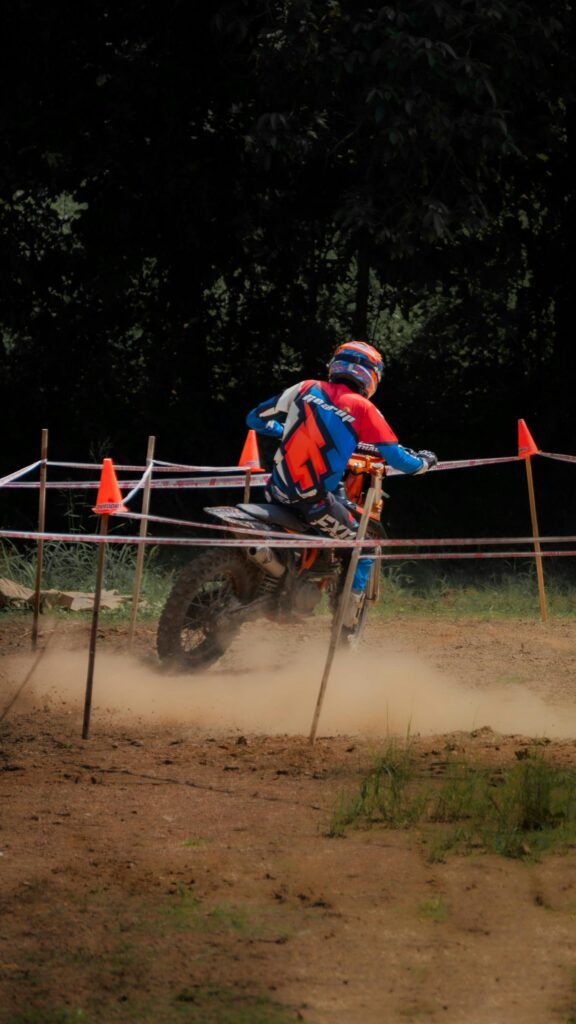 Adrenaline-Fueled Motocross Dirt Bike Rider Racing Through Dust Wallpaper