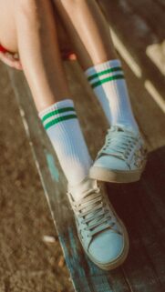 Vintage Aesthetic Legs in Green Striped Socks and Sneakers Wallpaper