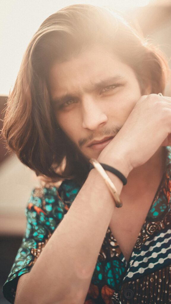Handsome Young Man with Long Hair and Stylish Shirt Mobile Wallpaper