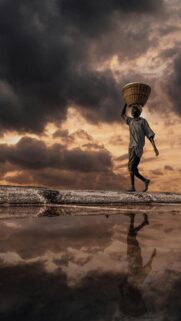 Stunning Salt Farmer Silhouetted Against Dramatic Stormy Sky Phone Wallpaper