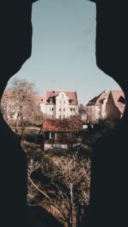 Charming Old Town View Through Stone Archway Mobile Wallpaper