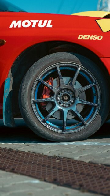 Red Rally Racing Car Wheel and Brake Caliper Close-up Mobile Wallpaper