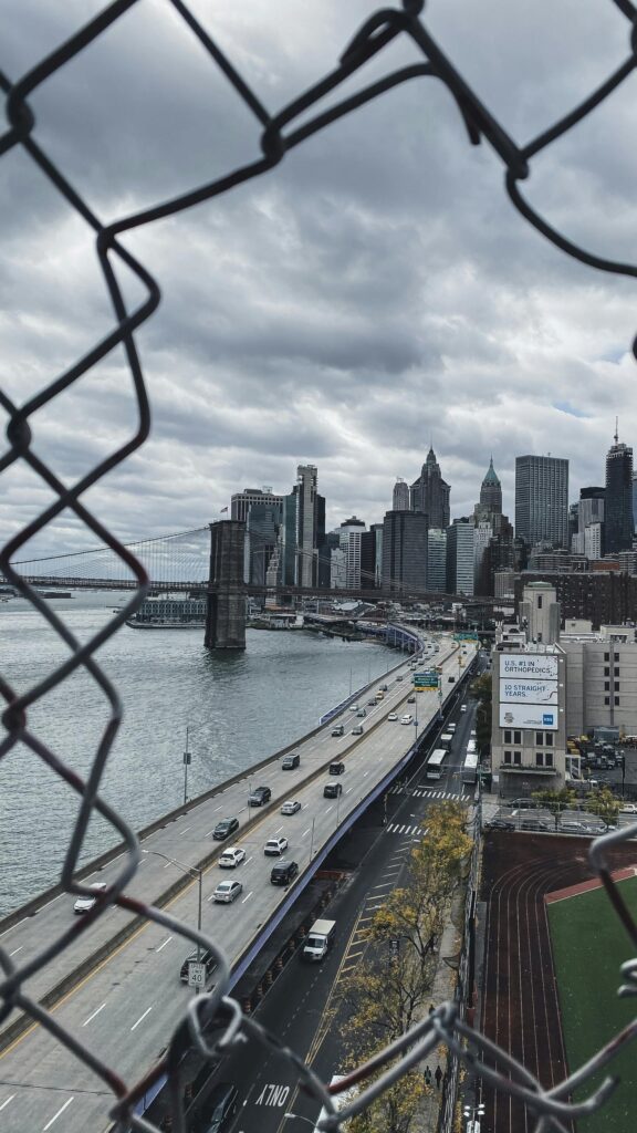 Brooklyn Bridge and New York City Skyline View Through Fence Wallpaper