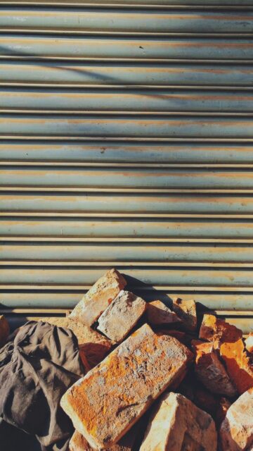 Rustic Grunge Brick Pile Against Industrial Metal Texture Wallpaper