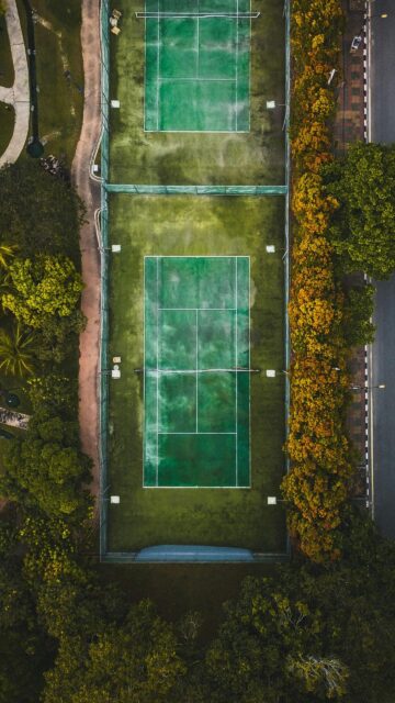 Aerial View of Tennis Courts Surrounded by Autumn Trees Mobile Wallpaper
