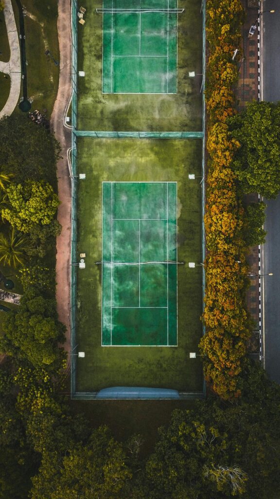 Aerial View of Tennis Courts Surrounded by Autumn Trees Mobile Wallpaper
