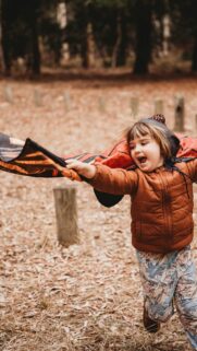 Joyful Child Playing Superhero in Butterfly Wings Costume Wallpaper