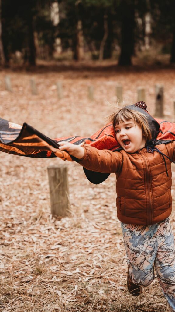 Joyful Child Playing Superhero in Butterfly Wings Costume Wallpaper