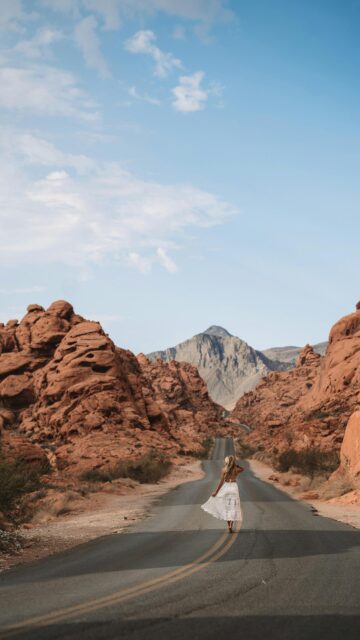 Woman Walking on Red Rock Desert Road Nature Mobile Wallpaper