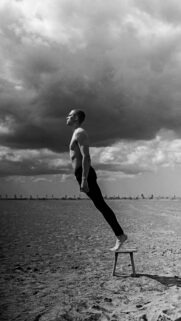 Surreal Man Levitating on a Stool Minimalist Black and White Wallpaper