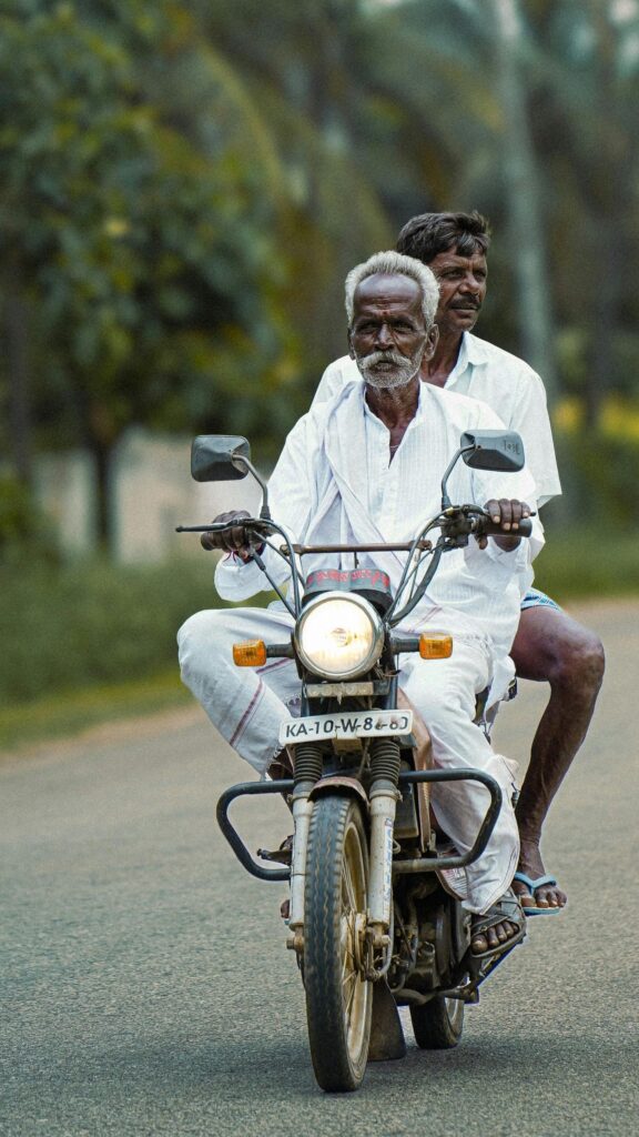 Two Men Riding Vintage Motorcycle Rural Road Mobile Wallpaper