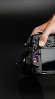 Professional Digital Camera in Hand Close-up Mobile Wallpaper