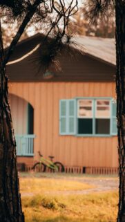 Charming Rustic Cottage with Green Bicycle at Sunset Mobile Wallpaper