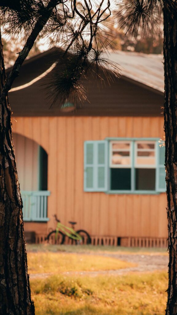 Charming Rustic Cottage with Green Bicycle at Sunset Mobile Wallpaper