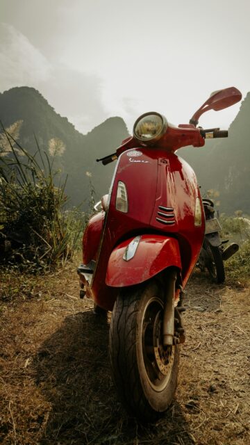 Stunning Red Vespa Scooter in Nature Landscape Mobile Wallpaper