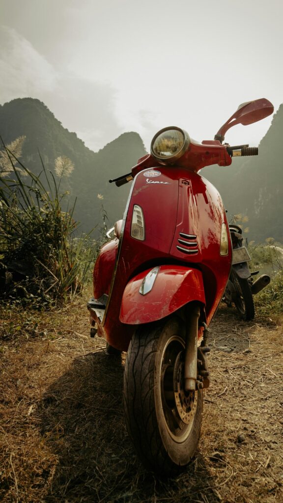 Stunning Red Vespa Scooter in Nature Landscape Mobile Wallpaper
