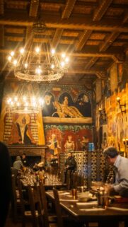 Medieval Banquet Hall with Ornate Murals and Chandeliers Mobile Wallpaper