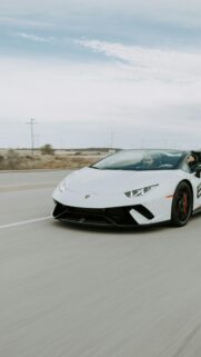 White Lamborghini Huracan Spyder Driving on Highway Mobile Wallpaper