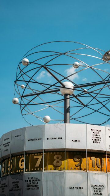 World Time Zone Sculpture Under Clear Blue Sky Phone Wallpaper