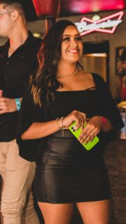 Stylish Woman Holding Lime Green Phone at Party Mobile Wallpaper