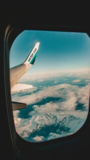 Aerial View of Snowy Mountains and WestJet Wing Plane Wallpaper