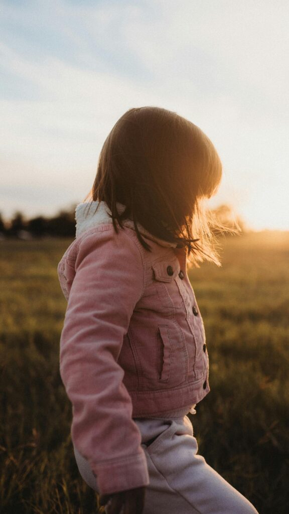 Little Girl in Pink Corduroy Jacket at Golden Hour Phone Wallpaper
