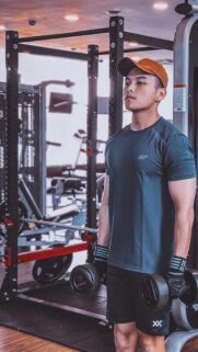 Determined Fitness Enthusiast Lifting Dumbbells Mobile Wallpaper