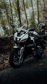 Silver Yamaha R15M Sportbike Resting in a Forest Grove Wallpaper
