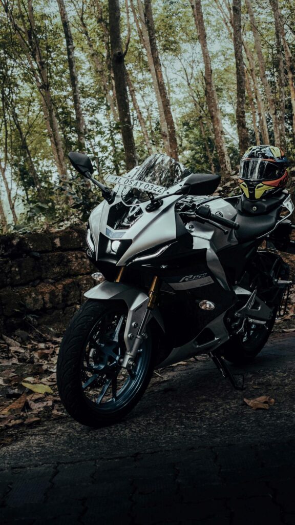 Silver Yamaha R15M Sportbike Resting in a Forest Grove Wallpaper