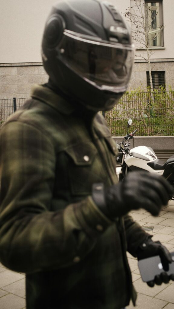 Biker in Camouflage Jacket with Helmet and Motorcycle Mobile Wallpaper