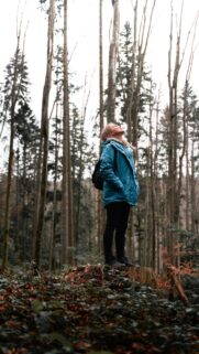 Woman Standing on Tree Stump in Forest Adventure Mobile Wallpaper