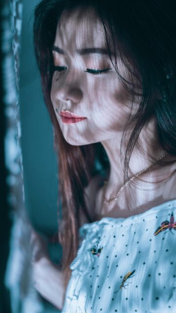 Dreamy Portrait of an Asian Girl with Light Shadows Mobile Wallpaper