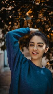 Beautiful Young Woman Posing Under Autumn Trees Mobile Wallpaper