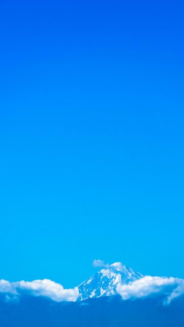 Majestic Snowy Mountain Peak Above Fluffy Clouds Phone Wallpaper