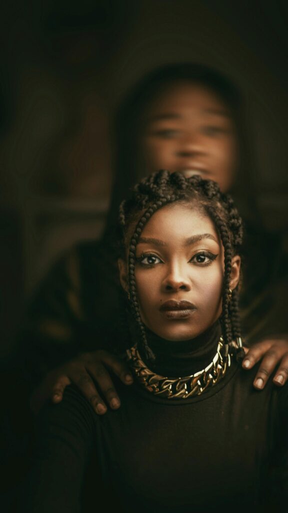 Stunning Portrait of a Woman with Braids and Gold Necklace Wallpaper