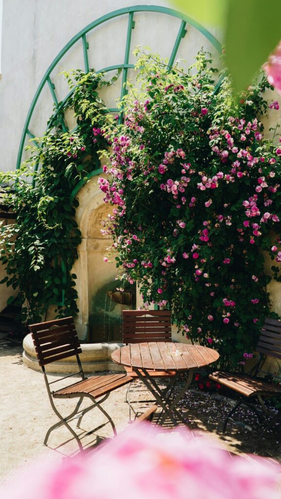 Romantic Garden Cafe Scene with Pink Flowers Phone Wallpaper