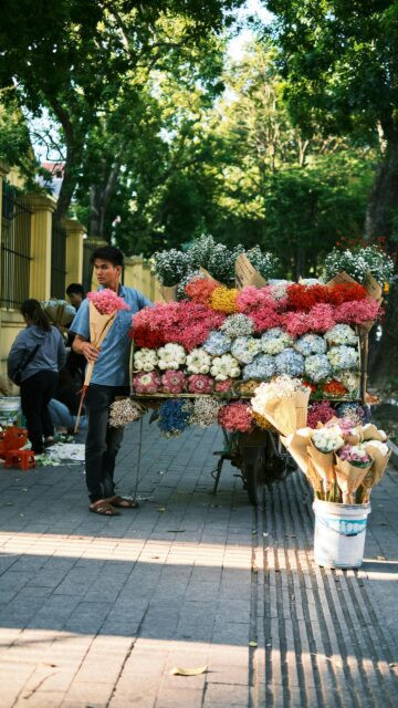 A Flower Vendor in Hanoi with Vibrant Colorful Bouquets Mobile Wallpaper