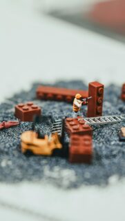 Miniature Construction Site with Toy Forklift and Lego Blocks Wallpaper