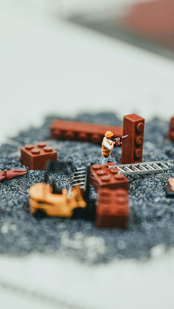 Miniature Construction Site with Toy Forklift and Lego Blocks Wallpaper