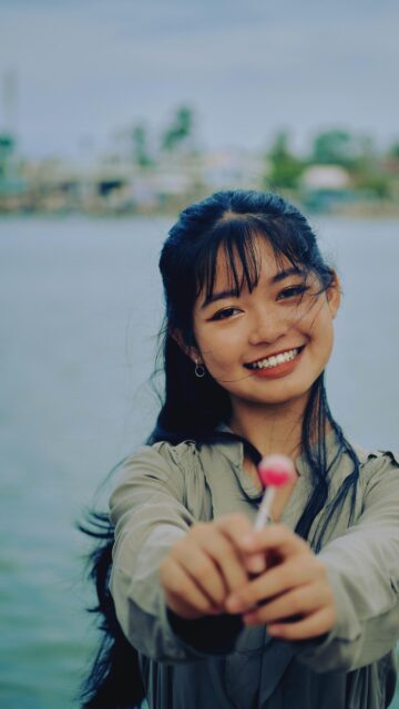 Asian Girl Smiling with Lollipop Mobile HD Wallpaper