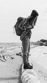 Solo Traveler Standing on Driftwood Beach Monochrome Mobile Wallpaper