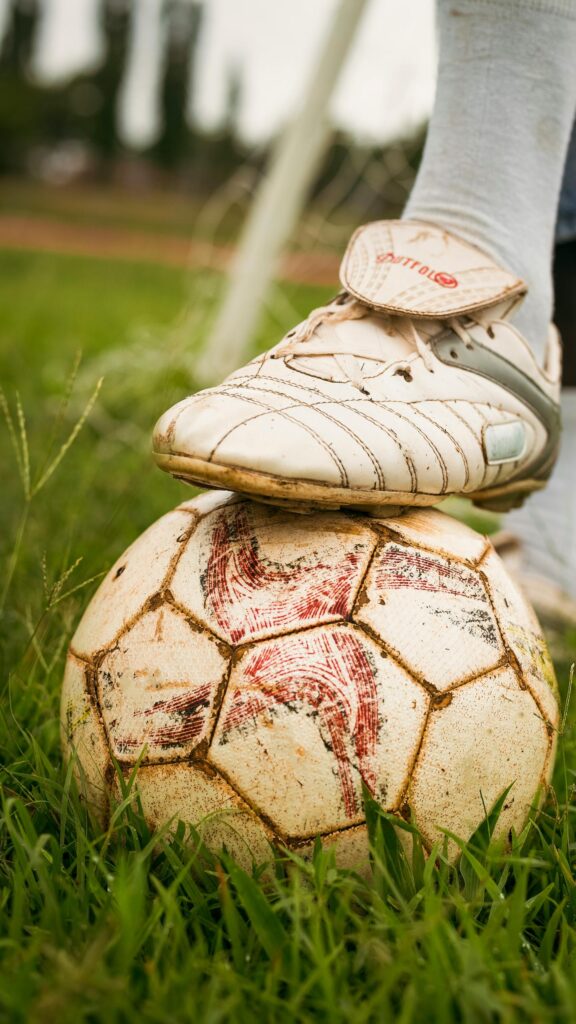Close-up Soccer Cleat on Worn Ball High Quality Mobile Wallpaper