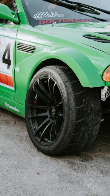 Close-up Green Racing Drift Car Wheel and Tire Phone Wallpaper