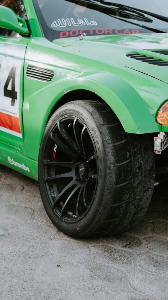 Close-up Green Racing Drift Car Wheel and Tire Phone Wallpaper