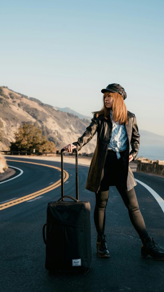 Stylish Traveler on Coastal Road Portrait Mobile Wallpaper