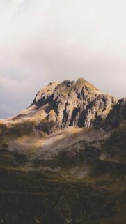 Stunning Rugged Mountain Peak Under Dramatic Sky Mobile Wallpaper