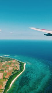 Aerial View of Tropical Island Coast and Airplane Wing Wallpaper