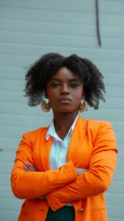 Confident Professional Woman in Bright Orange Blazer Portrait Wallpaper